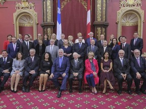 Members of the new Liberal cabinet pose for a photo at the National Assembly in Quebec City on Wednesday.