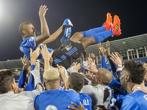 Montreal Impact's Patrcie Bernier is lifted up by teammates following his final MLS soccer game, against the New England Revolution in Montreal, Sunday, October 22, 2017.