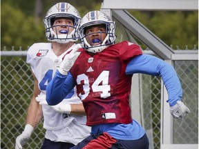 Linebacker Kyries Hebert, right, the East Division nominee as the most outstanding defensive player in the CFL, and fullback Jean-Christophe Beaulieu track the flight of a pass intended for Beaulieu during Alouettes training camp at Bishop's University in Lennoxville on May 30, 2017.