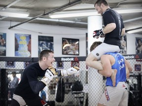 UFC fighter Joe Duffy plays along as sparring partner Zach Makovsky tries to make up height disadvantage by sitting on fellow fighter Arnold Allen's shoulders during training session at Tristar Gym in Montreal Wednesday October 25, 2017.