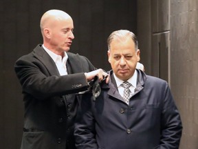 André Fortin, left, adusts the collar of Paolo Catania, former president of Construction Frank Catania & Associés Inc., on November 10, 2016.