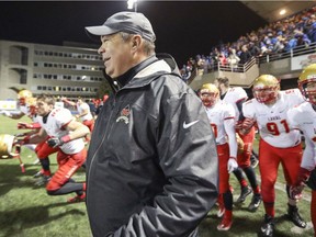Laval Rouge et Or head coach Glen Constantin smiles as his players run onto the field to celebrate their victory over Université de Montréal in the Quebec university football championship game in Montreal on Nov. 12, 2016.