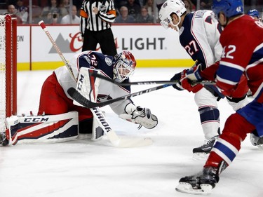 Columbus Blue Jackets goalie Sergei Bobrovsky makes a save against Montreal Canadiens centre Byron Froese as Columbus Blue Jackets defenceman Ryan Murray watches for a rebound during NHL action in Montreal on Tuesday November 14, 2017.