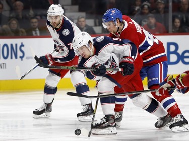 Montreal Canadiens defenceman Joe Morrow tips the puck away from Columbus Blue Jackets left wing Artemi Panarin as he tries to take a shot on net during NHL action in Montreal on Tuesday November 14, 2017. Columbus Blue Jackets left wing Nick Foligno looks on.
