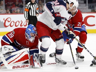 Montreal Canadiens goalie Charlie Lindgren follows the puck as Columbus Blue Jackets centre Boone Jenner tries to get hold of a rebound as Montreal Canadiens defenceman Karl Alzner tries to clear the puck during NHL action in Montreal on Tuesday November 14, 2017.