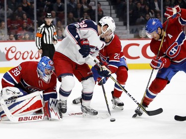 Montreal Canadiens goalie Charlie Lindgren follows the puck as Columbus Blue Jackets centre Boone Jenner tries to get hold of a rebound as Montreal Canadiens defenceman Karl Alzner and Montreal Canadiens defenceman Shea Weber, right, try to clear the puck during NHL action in Montreal on Tuesday November 14, 2017.