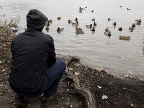 A victim of convicted pedophile Olivain Leblanc pauses to feed some ducks during a walk along a river in Montreal on Thursday, Nov. 16, 2017.