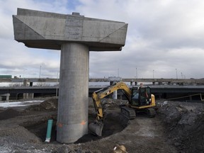 Crews install a drainage pipe at the base of a support column as part of the Turcot Interchange project in Montreal Nov. 20, 2017.
