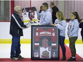 Hockey West Island retired the midget AA jersey of Tristan Morrissette-Perkins, who died tragically July 3 when he was struck by a VIA passenger train on a rail bridge near Lancaster, Ont. Tristan’s parents, Jay and Julie and sister Allison accept a photograph from Dorval Mayor Edgar Rouleau during a jersey retirement ceremony for Tristan on Nov. 19.