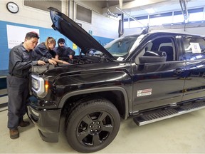 Zheng Li (left to right), August Darey and Jora Khalsa check out the engine on the GMC pickup truck donated to the West Island Career Centre by GMC Canada in Pierrefonds on Monday.