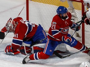 Canadiens goalie Carey Price smothers the puck while teammate David Schlemko clears the front of the net Wednesday night at the Bell Centre.