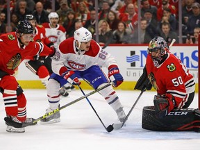 Corey Crawford #50 of the Chicago Blackhawks drops to stop a shot by Andrew Shaw #65 of the Montreal Canadiens as Jan Rutta #44 defends at the United Center on November 5, 2017 in Chicago, Illinois.