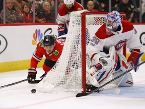 Artem Anisimov of the Chicago Blackhawks falls to the ice trying to get off a shot against Charlie Lindgren of the Montreal Canadiens at the United Center on November 5, 2017 in Chicago, Illinois. The Canadiens defeated the Blackhawks 2-0.