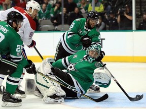 Stars' Gemel Smith clears the puck from behind goalie Ben Bishop during second period Tuesday night in Dallas.