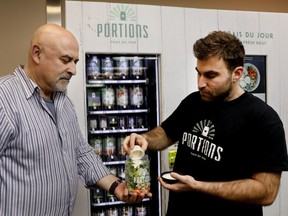 Aaron Hutman his son, Ryan, demonstrate the concept behind a new salad vending machine they have installed at Central Station.