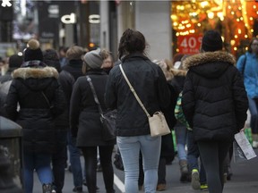 Christmas shoppers walk along Ste-Catherine St. in Montreal.