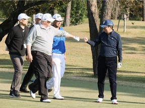 In this handout picture released by Japan's Cabinet Public Relations Office via Jiji Press, U.S. President Donald Trump (C) gestures to Japanese Prime Minister Shinzo Abe (R) while playing golf with Japanese professional golfer Hideki Matsuyama (2nd right) at the Kasumigaseki Country Club Golf Course in Kawagoe, Saitama prefecture, outside Tokyo on November 5, 2017.