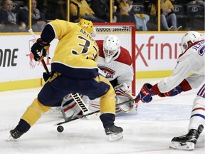 Canadiens defenceman Jakub Jerabek pokes the puck away from Predators' Viktor Arvidsson as goalie Antti Niemi guards Montreal's net Wednesday night in Nashville.