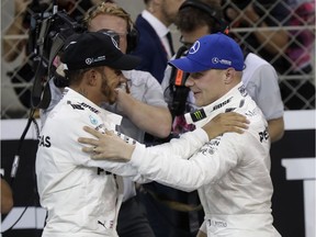 Mercedes driver Valtteri Bottas, right, of Finland, celebrates with his teammate second placed Lewis Hamilton, of Britain, after setting the pole position during the qualifying session at the Yas Marina racetrack in Abu Dhabi, United Arab Emirates, Saturday, Nov. 25, 2017. The Emirates Formula One Grand Prix will take place on Sunday. (AP Photo/Luca Bruno)