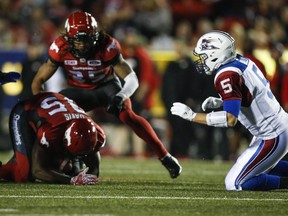 Montreal Alouettes quarterback Drew Willy (5) looks on as Calgary Stampeders defensive lineman Ja'Gared Davis (95) recovers a fumble during second half CFL football action in Calgary, Friday, Sept. 29, 2017.