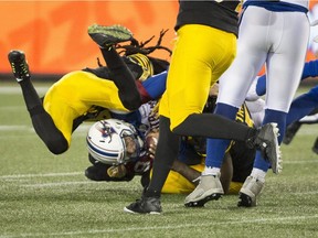 Alouettes rookie quarterback Matthew Shiltz is sacked by Tiger-Cats defensive-back Abdul Kanneh (14) and teammate Adrian Tracy (5) during first half CFL football action in Hamilton, Ont., Friday.