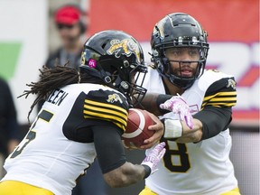 Tiger-Cats quarterback Jeremiah Masoli hands off to teammate Alex Green during first half action against the Alouettes on Sunday, October 22, 2017
