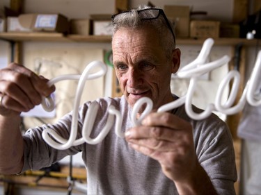 Glass artist Gerald Collard checks out one of his latest neon sign Wednesday, November 1, 2017 in Montreal. THE CANADIAN PRESS/Paul Chiasson