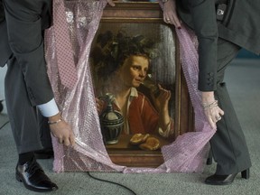 FBI agents unwrap Young Man As Bacchus, by Jan Franse Verzijl, before the start of a ceremony to formally return the painting to representatives of the Max and Iris Stern Foundation in 2017.