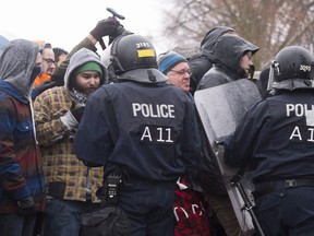 Quebec police officers push back anti-fascist demonstrators during a clash in Quebec City on Nov. 25, 2017 with extreme right groups. THE CANADIAN PRESS/Jacques Boissinot