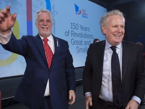 Quebec Premier Philippe Couillard, left, and former Quebec premier Jean Charest arrive on stage at the 150th anniversary celebrations of the Quebec Liberal Party Saturday, November 25, 2017 in Quebec City.