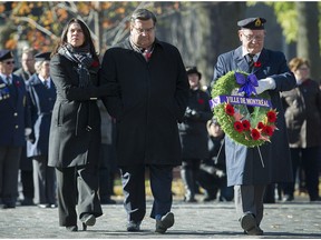 Outgoing Montreal mayor Denis Coderre, centre, and mayor-elect Valérie Plante lay a wreath during a Remembrance Day ceremony in Montreal, Saturday, Nov. 11, 2017.