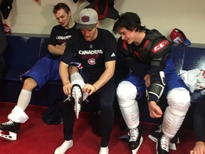 Canadiens forward Andrew Shaw, centre, removes skate for teammate Artturi Lehkonen as Charles Hudon looks on after team's practice at the Bell Sports Complex in Brossard on Monday, Nov. 13, 2017.