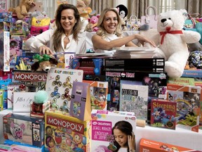 Co-chairs Erika Ludwik, left, and her sister Paulina Flores Rutenberg are surrounded by toys collected at the Ritz-Carlton on Dec. 6.