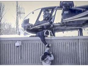 March 15, 2013: An accomplice tries to help Benjamin Hudon-Barbeau into a helicopter on the roof of the the St-Jerome detention centre.