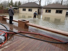 Rachel Dow makes her way to the garage to get motor oil for two pumps that are getting the water level in her parent's basement to about two inches in Hudson on May 8, 2017.