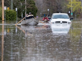 Residents row past an abandoned pickup truck on 5th Ave. N. in the Roxboro district of Montreal on Tuesday, May 9, 2017.