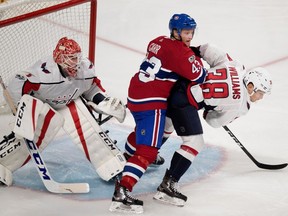 Montreal Canadiens' Daniel Carr knocks Washington Capitals Colby Williams to the ice as goalie Phoenix Copley looks on during preseason play at the Bell Centre in Montreal on Sept. 20, 2017.