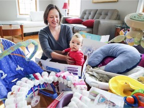 Kim Beardsell with daughter Charlotte-Rose among some of the donated items of baby clothes and accessories that she is collecting for teen mothers at her home in St-Lazare.