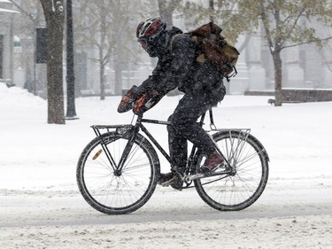 A bicycle courier makes his way up Peel St. during a snowstorm in Montreal Dec. 12, 2017.