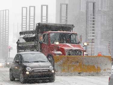 A snowplow makes its way up Robert-Bourassa Blvd. in Montreal Dec. 12, 2017.