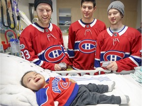 Canadiens Alex Hemsky, Carey Price and Paul Byron visit with 9-month-old Samuel Kanatewat during the team's annual Christmas visit to the Montreal Children's Hospital.