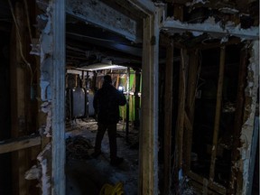 Tauseef Bhatti uses his cell phone to inspect the basement damage to his home on Saturday after this year's spring flood ruined their Ile-Bizard home. The Bhatti family, still waiting for the go-ahead to rebuild their home, is living out of hotels as a result.