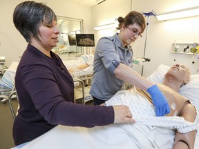 John Abbott College nursing student Vanessa Gauthier (right) simulates listening to a patient's heart on a hi-tech dummie under supervision of nursing instructor Tia Nymark in the program's simulated emergency room in Ste-Anne-de-Bellevue. The JAC nursing program was recently awarded the 2017 SIM Innovator Award, which recognizes excellence in the integration of simulation in education.