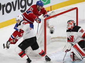 Montreal Canadiens' Max Pacioretty falls onto the net of New Jersey Devils goalie Cory Schneider, while New Jersey Devils' Steven Santini catches up on the play, during first period NHL action in Montreal on Thursday December 14, 2017.