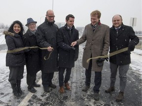 Andre Fortin, third from right, Minister of Transport cuts a ribbon during the announcement of the long awaited exit ramp from Highway 20 west to Trudeau airport in Dorval as the ramp gets set to open overnight on Monday, December 18, 2017.