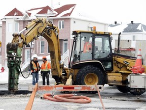 Workers repair a water main break on Pierrefonds Blvd. near Sources Blvd. in Pierrefonds on Friday.