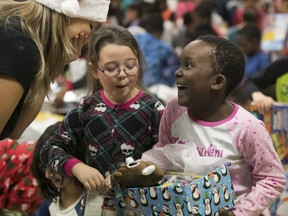 Grade 2 students from Jules-Verne Elementary school open their presents bought through the donations of employees of local companies on Friday Dec. 22, 2017.