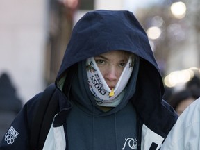 Paul Rabaud of France tries to cover as much of his face as he can as walks along Sainte-Catherine Street while Montreal enters a cold snap on Wednesday December 27, 2017.