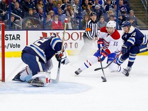 Canadiens' Chris Terry is checked from behind by Blue Jackets' Markus Nutivaara as he attempts to get a shot off against Sergei Bobrovsky last year in Columbus, Ohio.