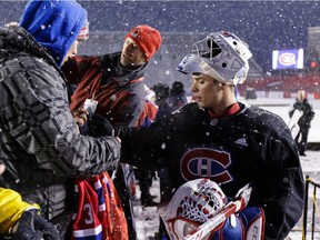 Carey Price #31 of the Montreal Canadiens signs an autograph for a fan following practice at Lansdowne Park on December 15, 2017 in Ottawa, Canada.